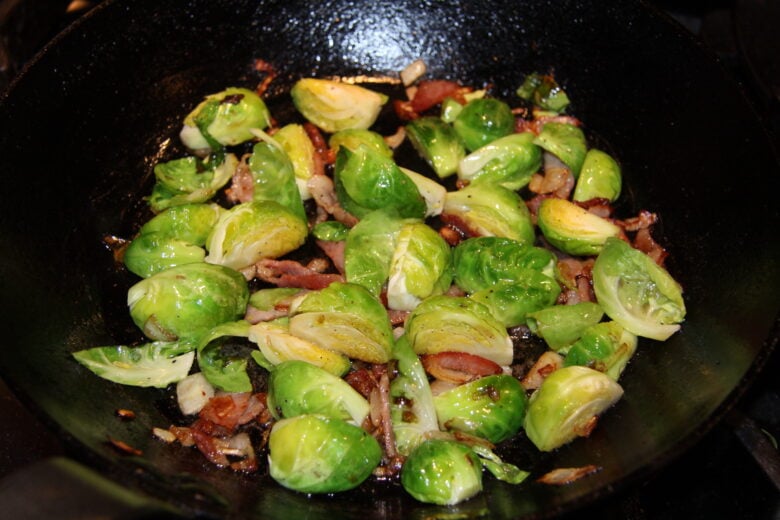 brussels sprouts with bacon on a black pan