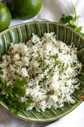 cilantro lime rice in a green dish with red chopsticks