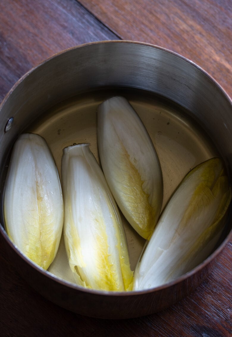 Endive Ham Gratin - endives in a pan with wine and water