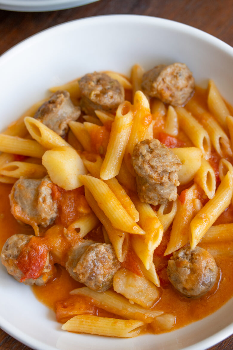 Penne Pasta with Sausage and Tomatoes Ingredients in a serving white plate