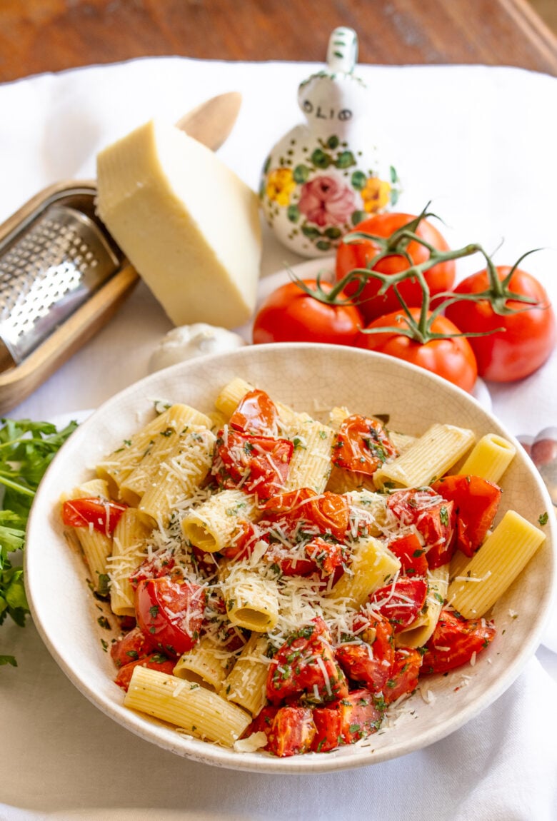 Rigatoni with Roasted Tomatoes surounded by fresh tomatoes and pecorino cheese