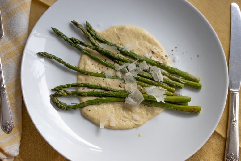 Roasted Asparagus with Parmesan Cream Sauce on a white plate