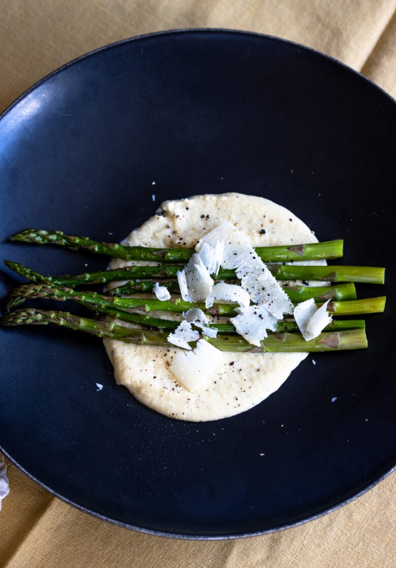 Roasted Asparagus with Parmesan Cream Sauce on a dark plate