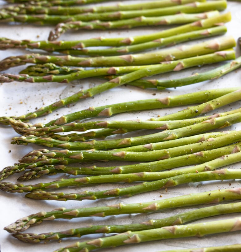 asparagus single layer on a cookie sheet with olive oil, salt and pepper