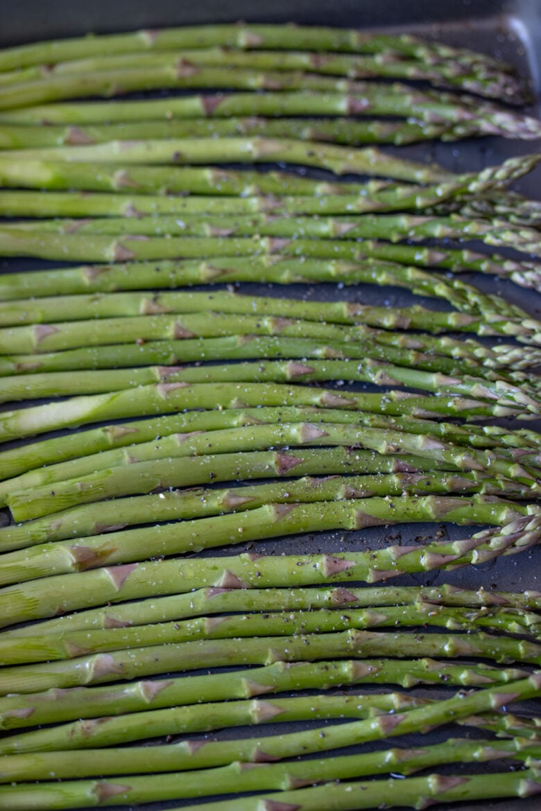 Roasted Parmesan Asparagus - seasoned with salt and pepper on a cookie sheet