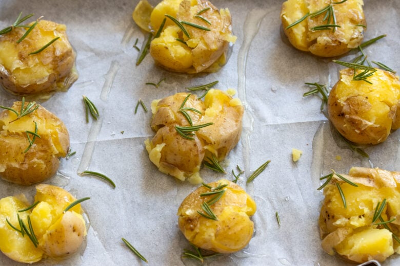 potatoes ready to go in the oven on a baking sheet