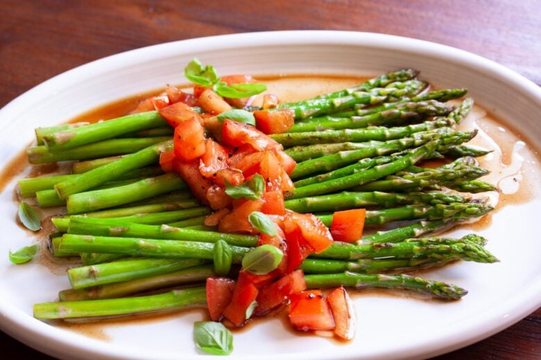 asparagus with balsamic vinaigrette on a white plate