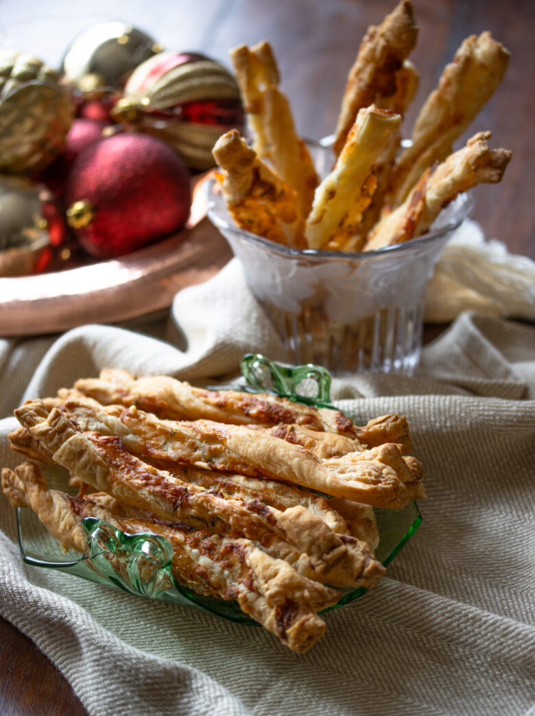 cheese and rosemary breadsticks in individula plates and with holiday ornaments next to them