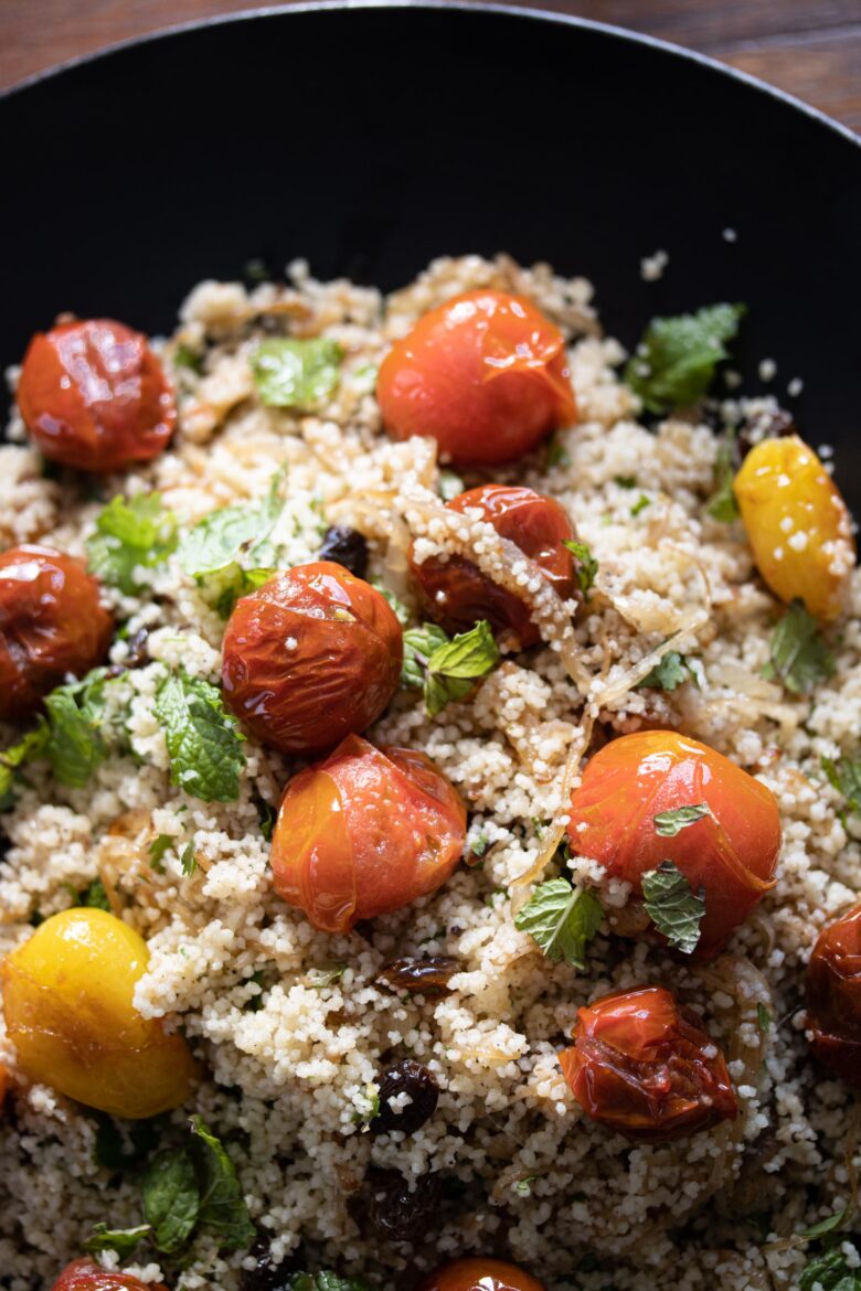 Couscous, Herbs, Tomatoes Salad with Scallops on a black plate