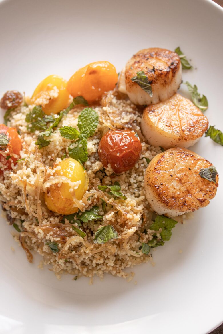 Couscous, Herbs, Tomatoes Salad with Scallops on a serving plate