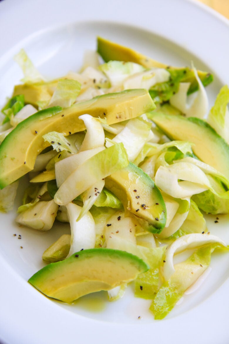 Belgian endive avocado salad on a white plate