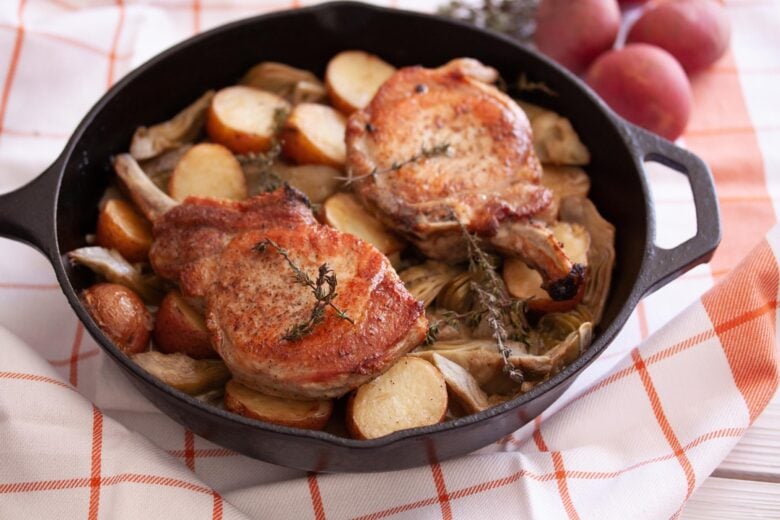 pork chops with artichokes and potatoes in a lodge skillet