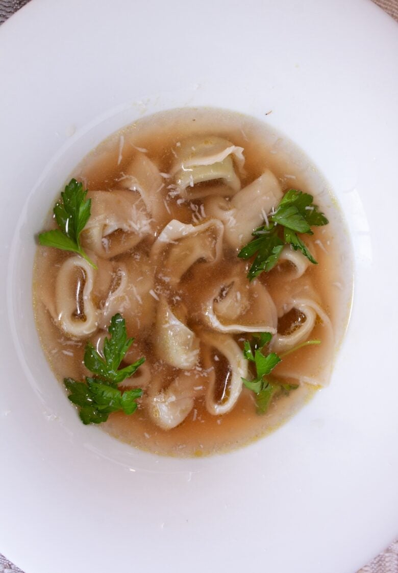 tortellini in broth in a white dish